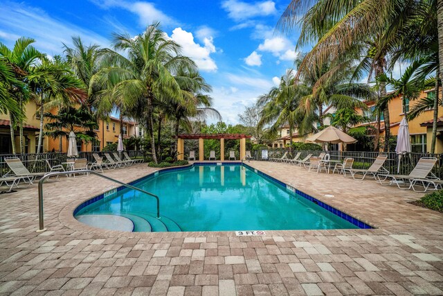 community pool with fence, a pergola, and a patio