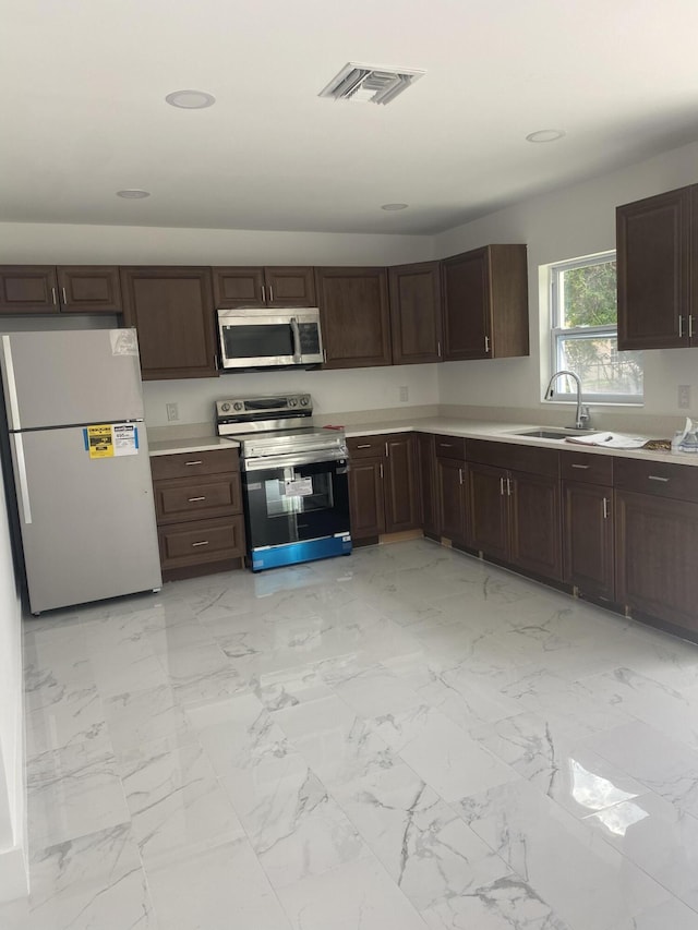 kitchen with sink, dark brown cabinets, and appliances with stainless steel finishes