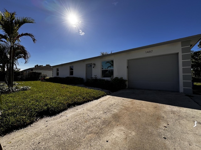 ranch-style house featuring a garage and a front yard