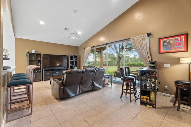 living room with ceiling fan, high vaulted ceiling, and light tile patterned flooring