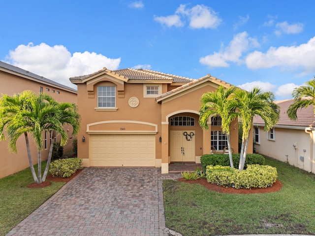 mediterranean / spanish-style house with a garage and a front lawn