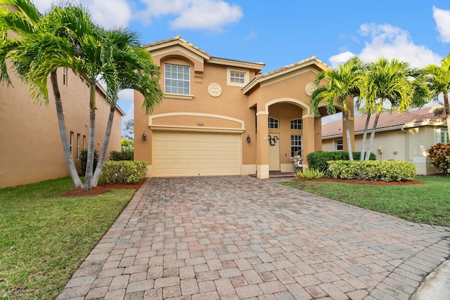 mediterranean / spanish home with a front yard and a garage