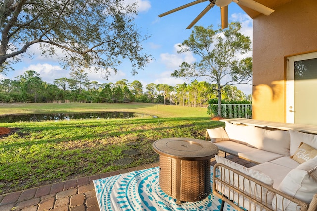 view of patio / terrace featuring a water view and ceiling fan