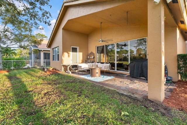 rear view of house with ceiling fan, a lawn, an outdoor hangout area, and a patio