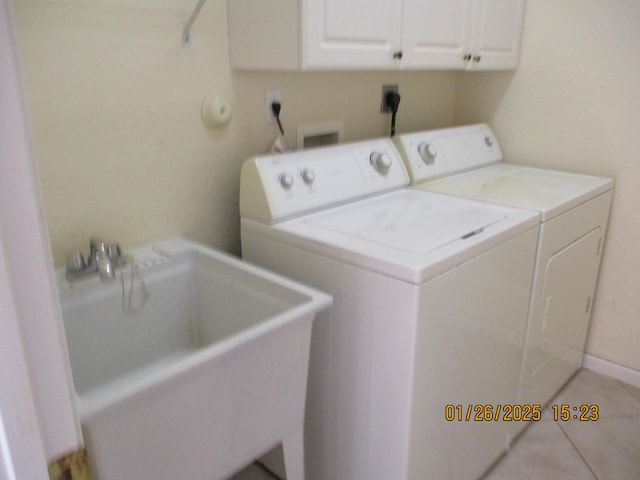 clothes washing area featuring cabinets, light tile patterned flooring, separate washer and dryer, and sink