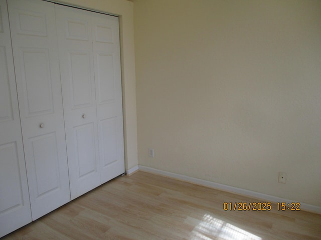 unfurnished bedroom with light hardwood / wood-style floors and a closet