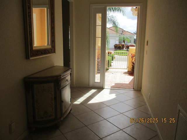 doorway with a wealth of natural light and tile patterned floors