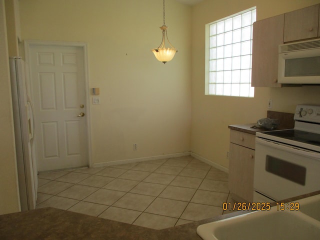 kitchen with pendant lighting, white appliances, and light tile patterned floors