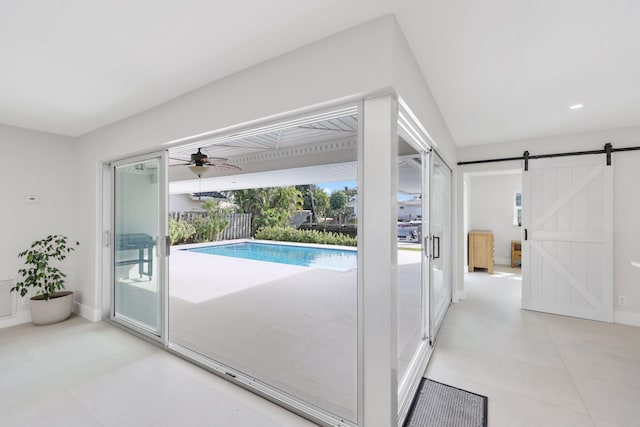 view of swimming pool featuring a barn door and ceiling fan