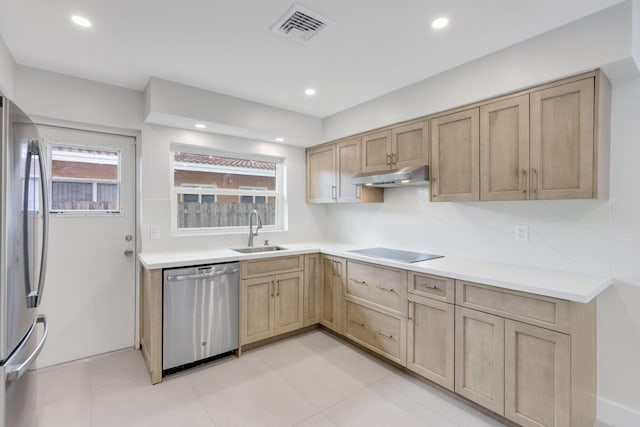 kitchen with sink, light tile patterned floors, appliances with stainless steel finishes, backsplash, and light brown cabinetry