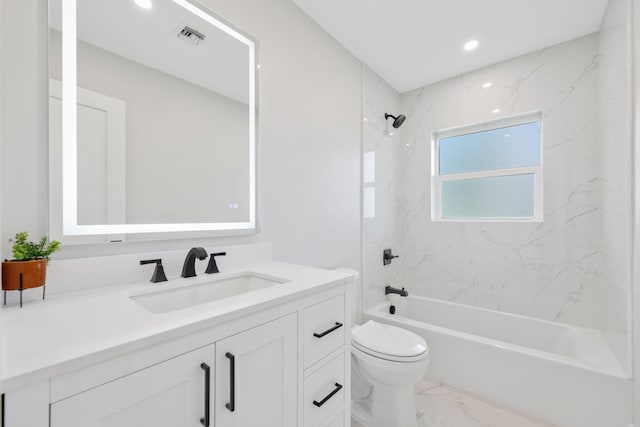 full bathroom featuring tiled shower / bath, vanity, and toilet