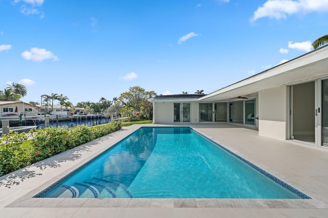 view of swimming pool with a water view and a patio area