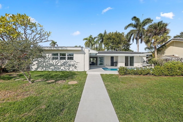 rear view of property featuring a lawn and a patio