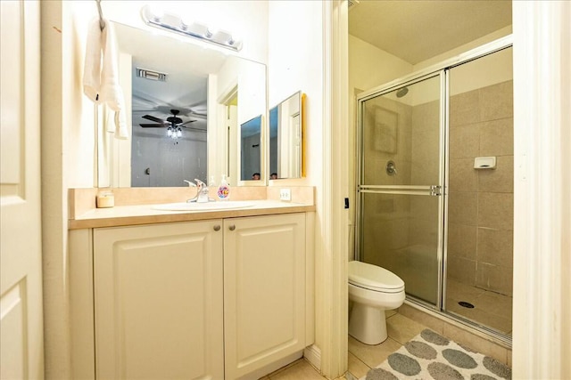 bathroom featuring ceiling fan, tile patterned flooring, vanity, a shower with shower door, and toilet