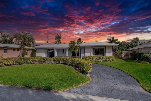 ranch-style home featuring a lawn