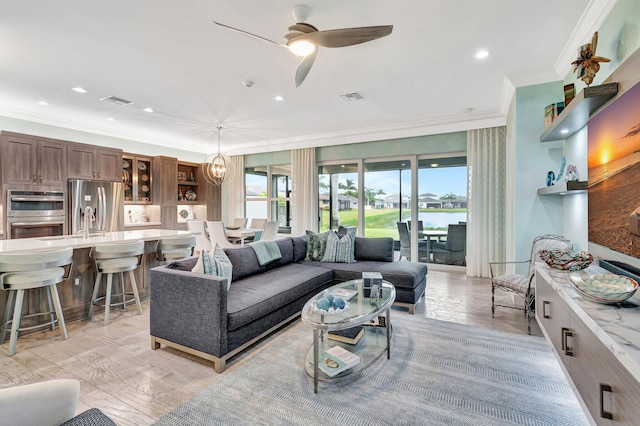 living room featuring a healthy amount of sunlight, ceiling fan, ornamental molding, and visible vents
