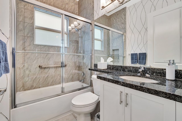 bathroom with toilet, vanity, and enclosed tub / shower combo