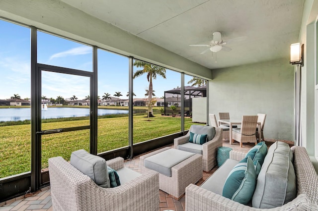 sunroom / solarium with a water view, a residential view, outdoor lounge area, and ceiling fan