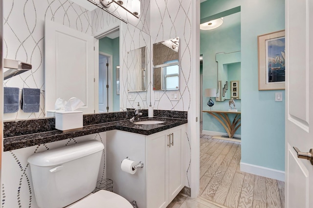 bathroom featuring wood-type flooring, vanity, and toilet