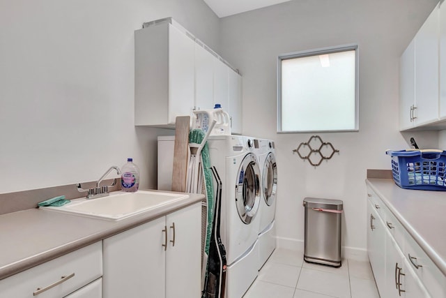 laundry room featuring cabinets, washer and dryer, sink, and light tile patterned floors