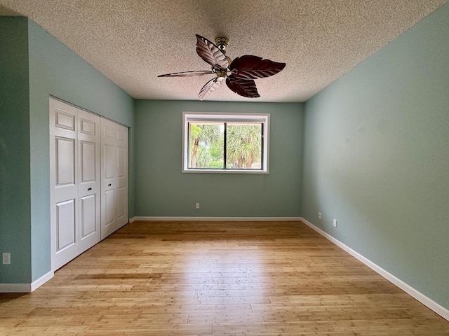 unfurnished bedroom with ceiling fan, a textured ceiling, light hardwood / wood-style flooring, and a closet