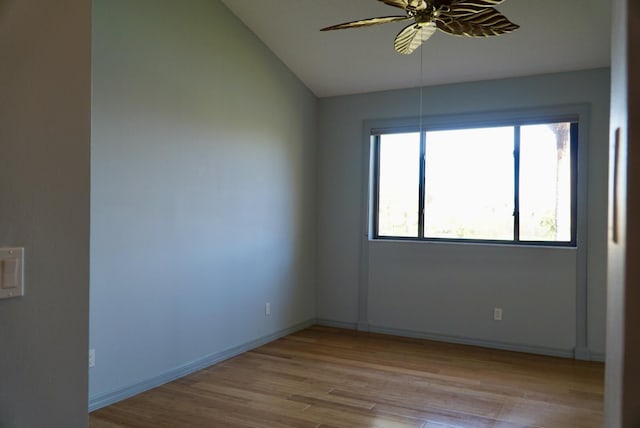 spare room featuring light wood-type flooring, vaulted ceiling, and ceiling fan