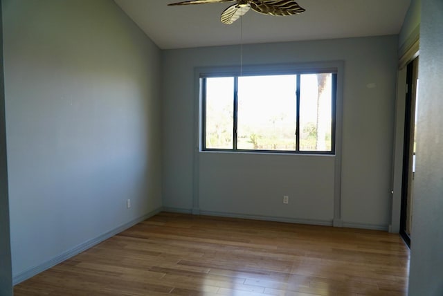 empty room featuring light hardwood / wood-style floors, vaulted ceiling, and ceiling fan