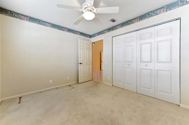 unfurnished bedroom featuring ceiling fan, a closet, and light carpet