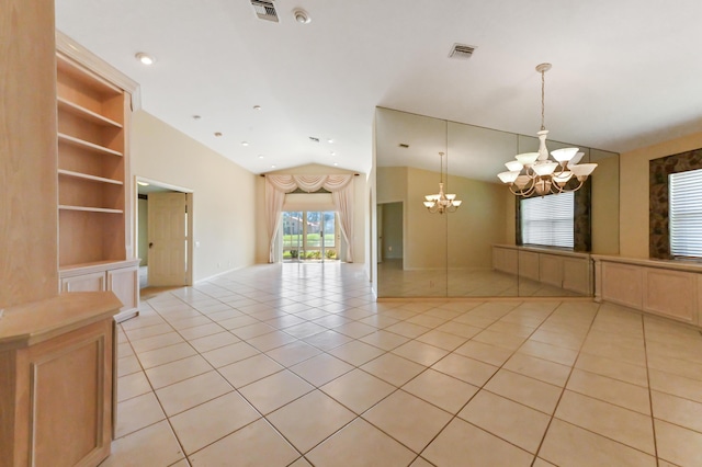 spare room with vaulted ceiling, light tile patterned floors, built in features, and a notable chandelier