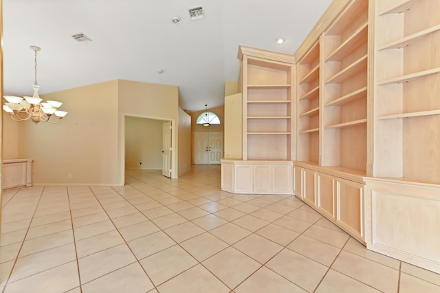 empty room featuring light tile patterned floors, a chandelier, and built in shelves