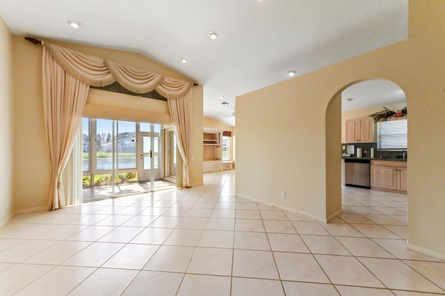 tiled empty room with a water view and vaulted ceiling