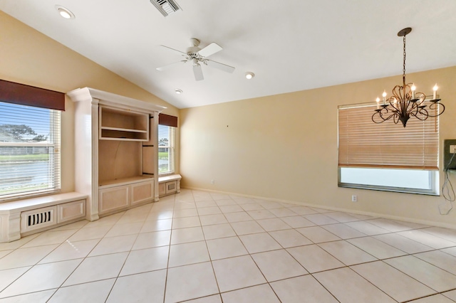 unfurnished living room with lofted ceiling, a healthy amount of sunlight, ceiling fan with notable chandelier, and light tile patterned floors