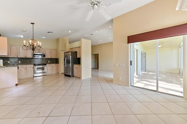 kitchen with light tile patterned flooring, appliances with stainless steel finishes, decorative light fixtures, tasteful backsplash, and sink