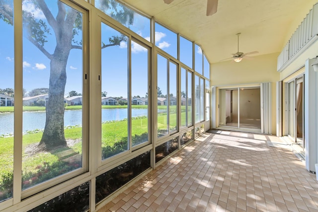 unfurnished sunroom with a water view and ceiling fan