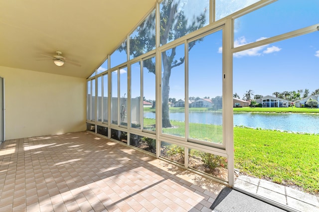 unfurnished sunroom featuring vaulted ceiling, a water view, and ceiling fan