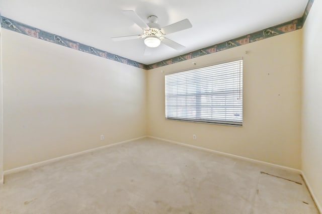 carpeted spare room featuring ceiling fan