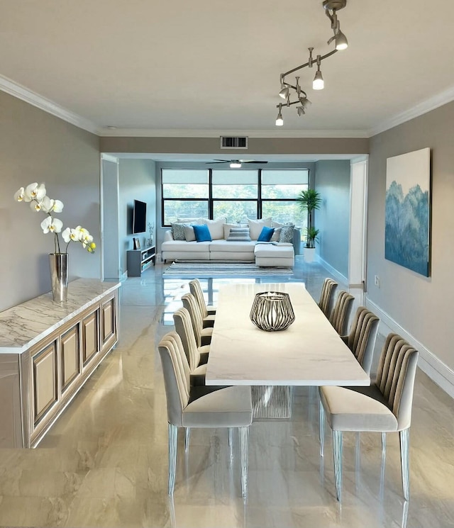 dining room featuring track lighting and ornamental molding