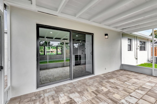 unfurnished sunroom with beam ceiling