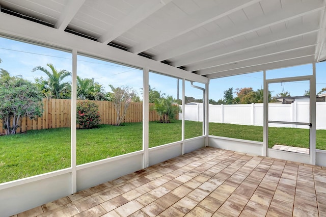 unfurnished sunroom with beam ceiling