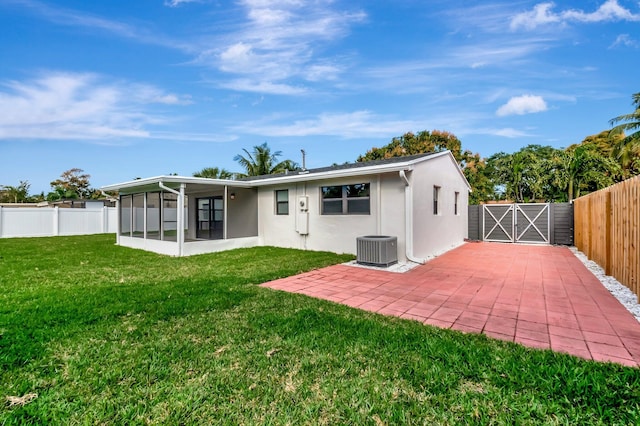 back of property with central AC unit, a yard, a sunroom, and a patio