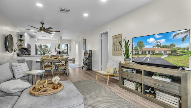 living room with ceiling fan and light hardwood / wood-style flooring