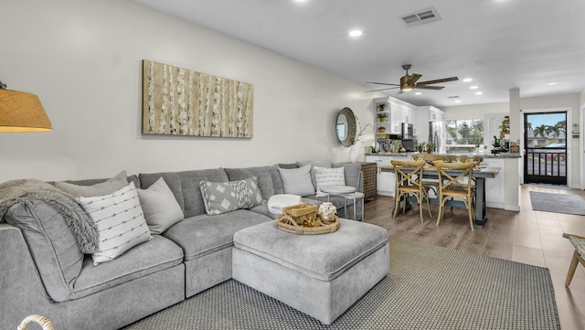 living room with wood-type flooring and ceiling fan