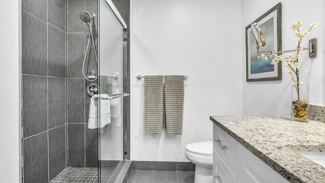 bathroom with a shower with door, tile patterned floors, toilet, and vanity