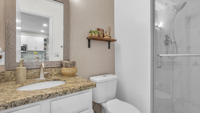 bathroom with toilet, an enclosed shower, and vanity