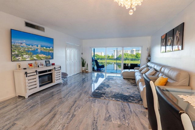 living room with baseboards, wood finished floors, visible vents, and a notable chandelier