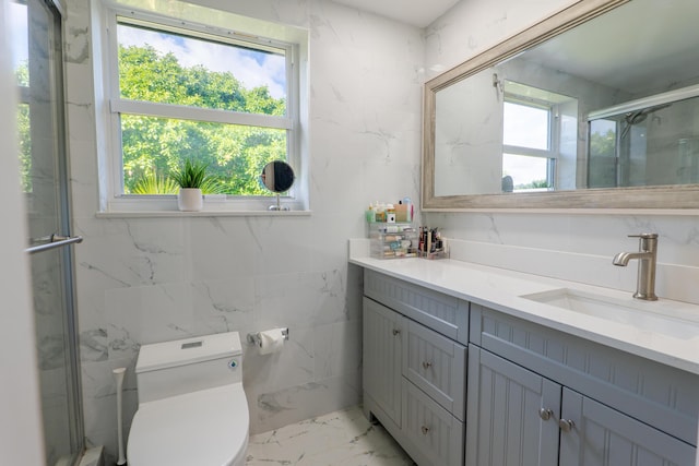 bathroom with vanity, a shower with shower door, toilet, and a healthy amount of sunlight