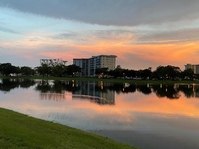 surrounding community with a yard and a water view