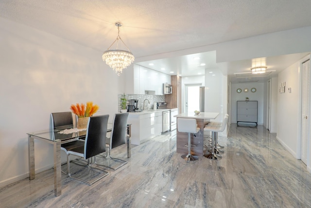 dining room with a textured ceiling, marble finish floor, a notable chandelier, and baseboards