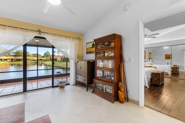 interior space featuring a water view, lofted ceiling, and ceiling fan