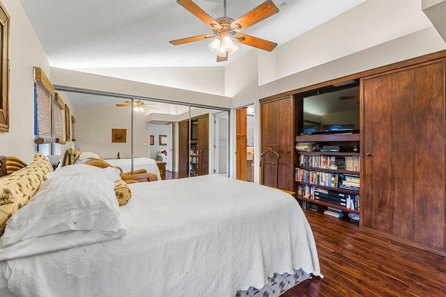 bedroom with ceiling fan, dark hardwood / wood-style floors, vaulted ceiling, and a textured ceiling